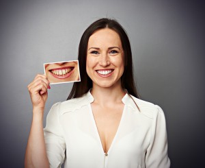 woman holding picture with yellow teeth